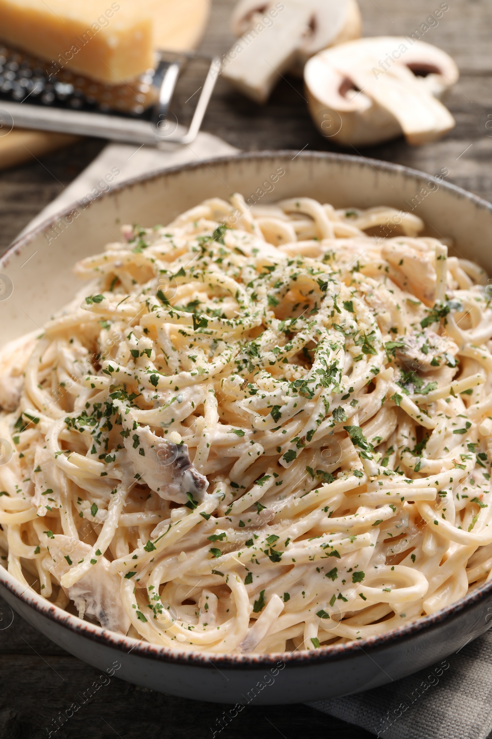 Photo of Delicious pasta with mushroom sauce on wooden table, closeup