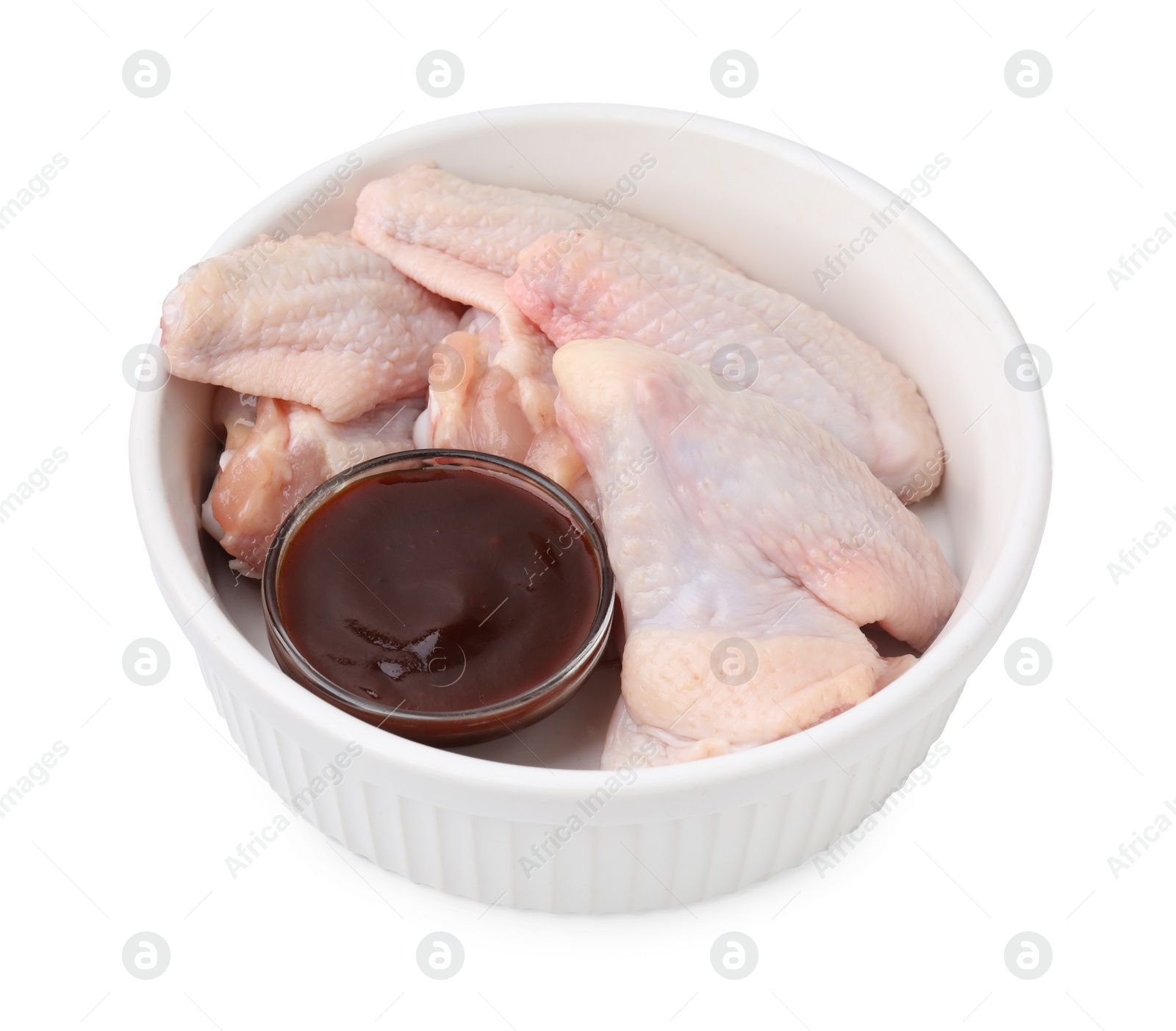 Photo of Fresh marinade and raw chicken wings in bowl isolated on white