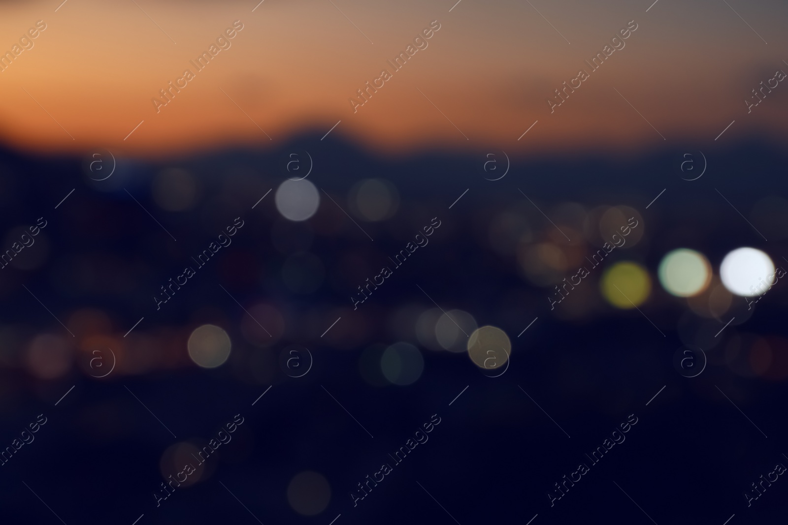 Photo of Blurred view of beautiful sunset with mountains in city, bokeh effect