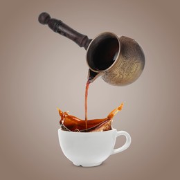 Image of Pouring freshly brewed aromatic coffee from turkish pot into cup. Objects in air on dark dusty beige background