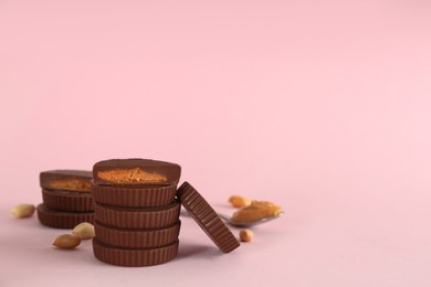 Photo of Sweet peanut butter cups on pink background. Space for text