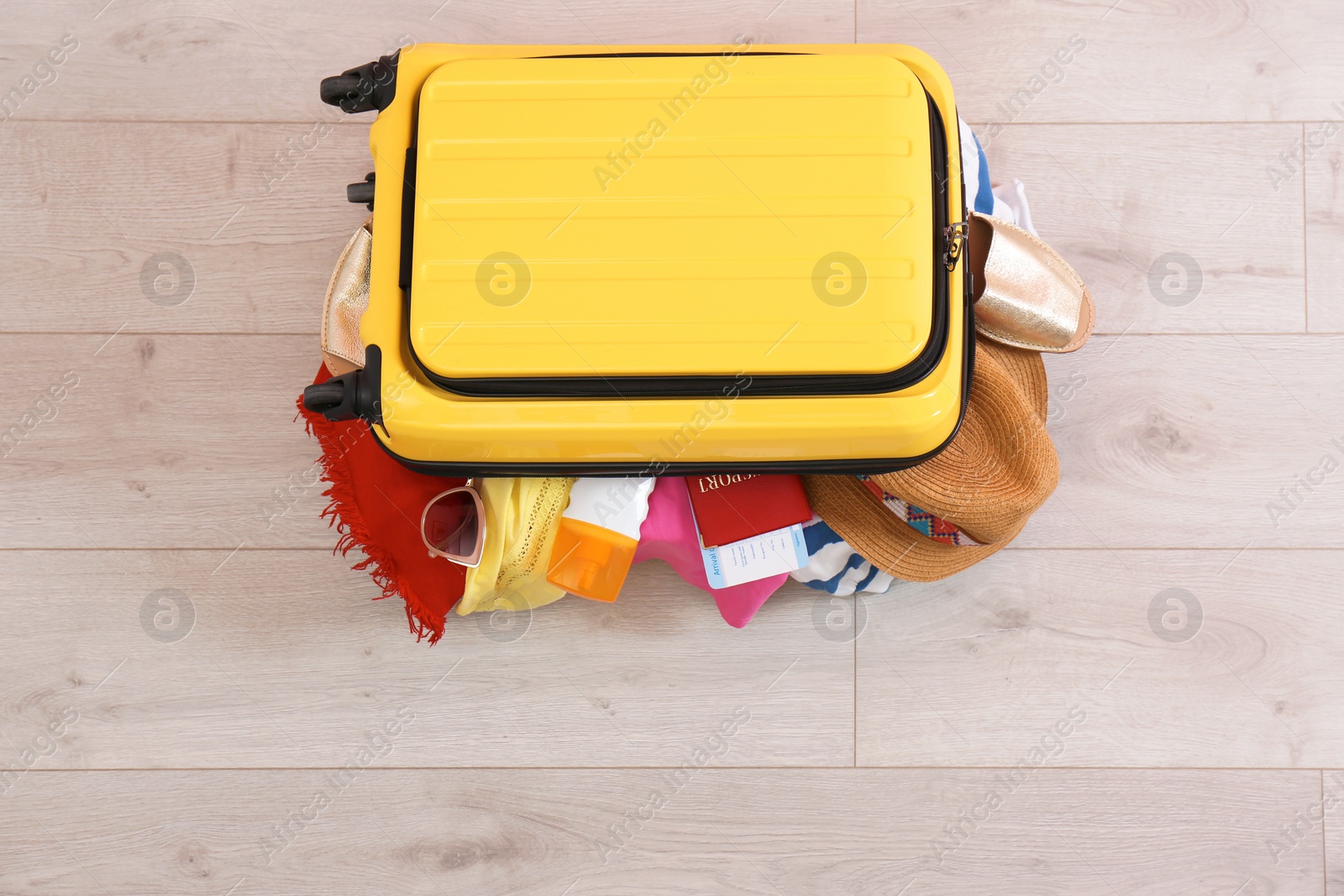 Photo of Bright suitcase with clothes on wooden background