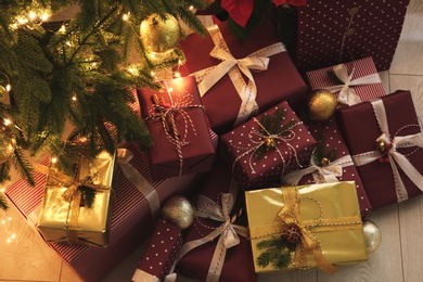 Photo of Many different gifts under Christmas tree indoors