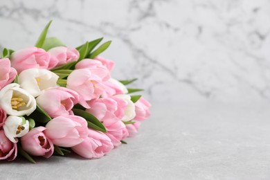 Photo of Beautiful bouquet of tulips on light table. Space for text