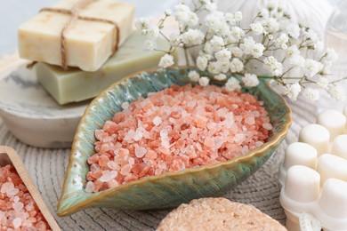 Photo of Sea salt, soap bars and dry shampoo on mat, closeup