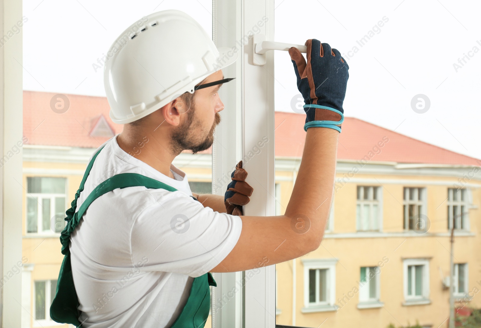 Photo of Construction worker installing new window in house