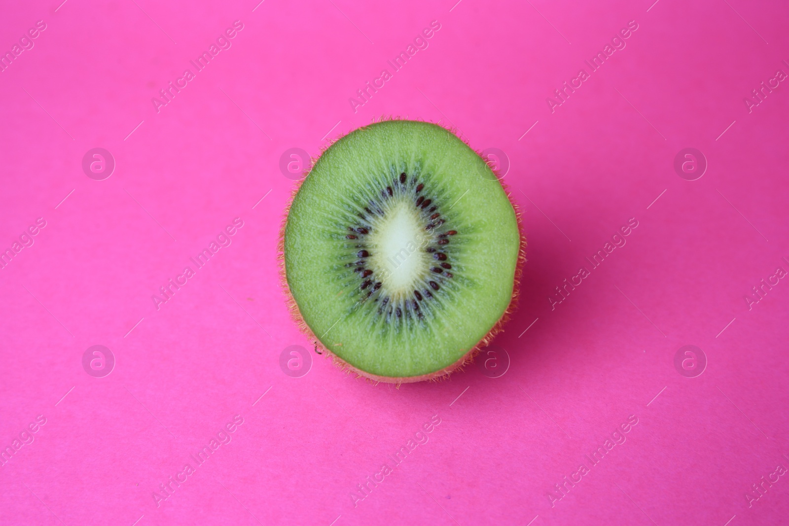 Photo of Cut fresh ripe kiwi on pink background