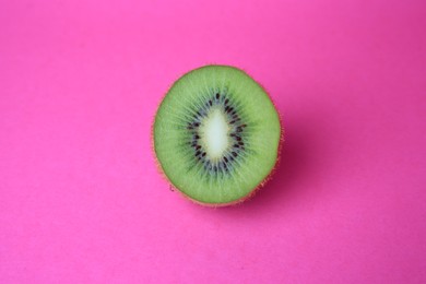 Cut fresh ripe kiwi on pink background