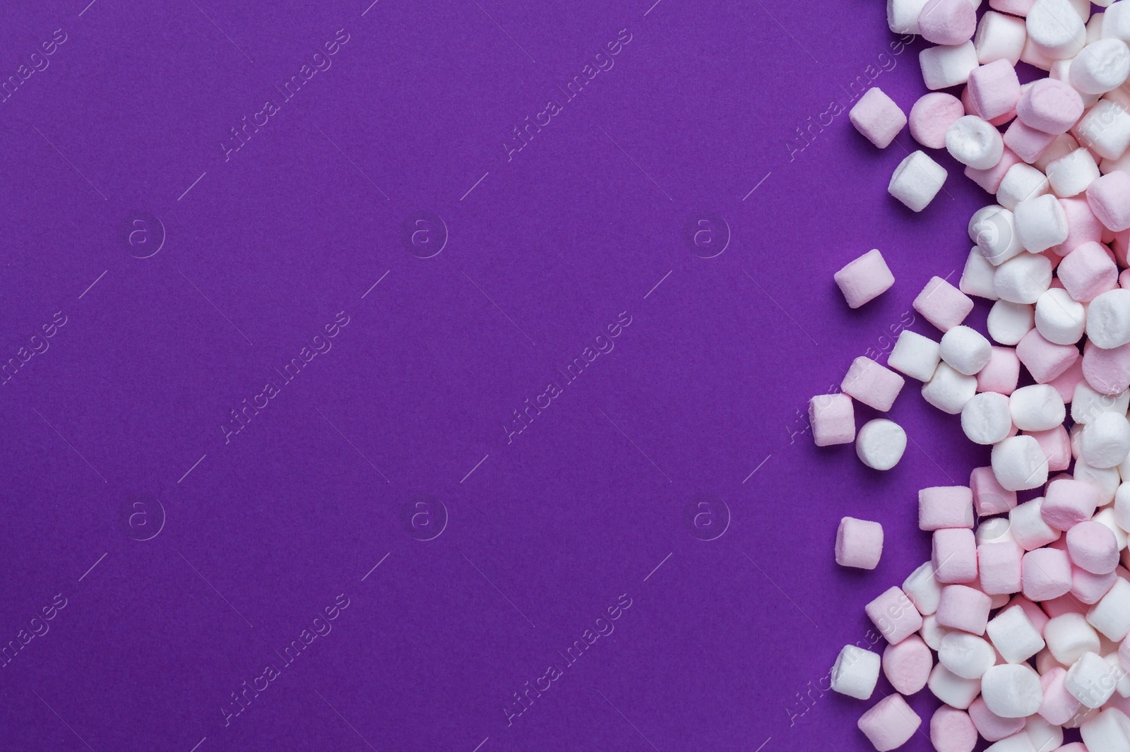 Photo of Delicious marshmallows on purple background, flat lay. Space for text