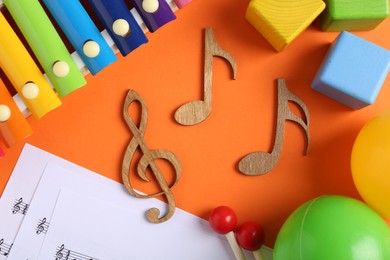 Photo of Creating baby songs. Flat lay composition with wooden notes on orange background
