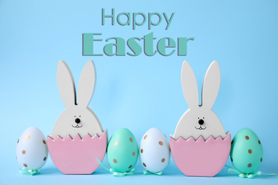 Easter bunnies and painted eggs on light blue background