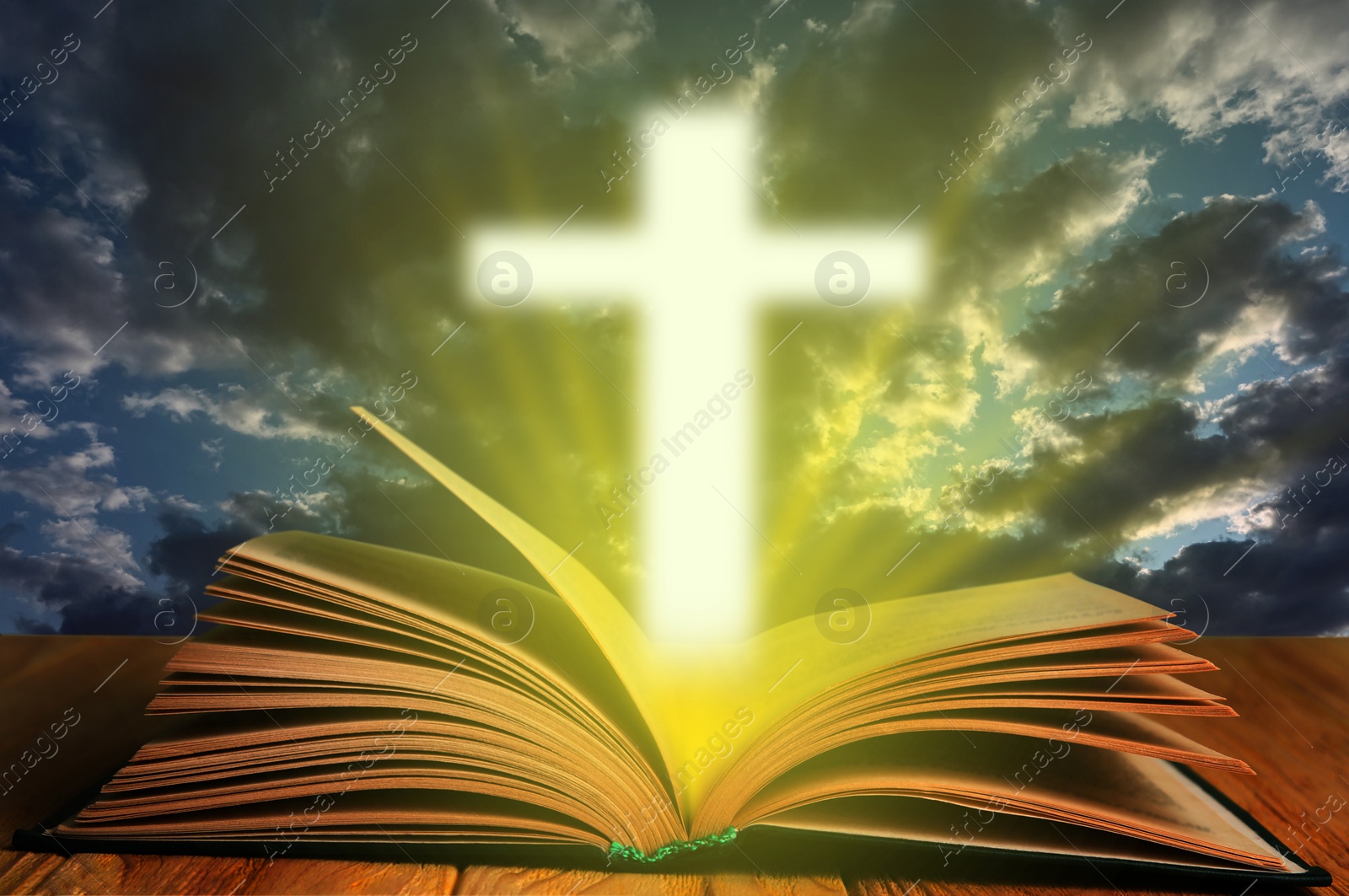 Image of Silhouette of cross and open Bible on wooden table against cloudy sky