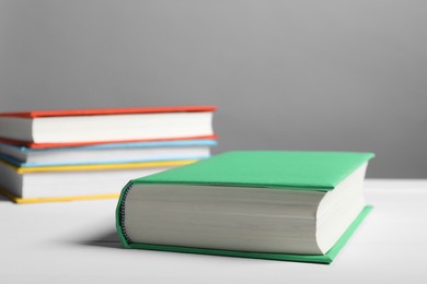 Photo of Different books on white table against gray background, closeup. Space for text