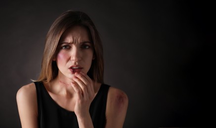 Photo of Woman with facial injuries on black background. Domestic violence victim