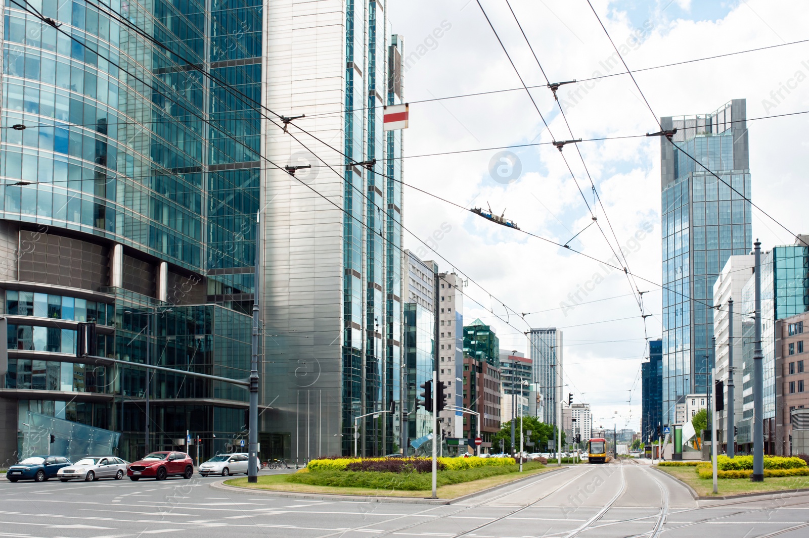 Photo of Road, cars and beautiful buildings on cloudy day in city