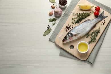 Photo of Tasty sea bass fish and ingredients on wooden table, flat lay. Space for text