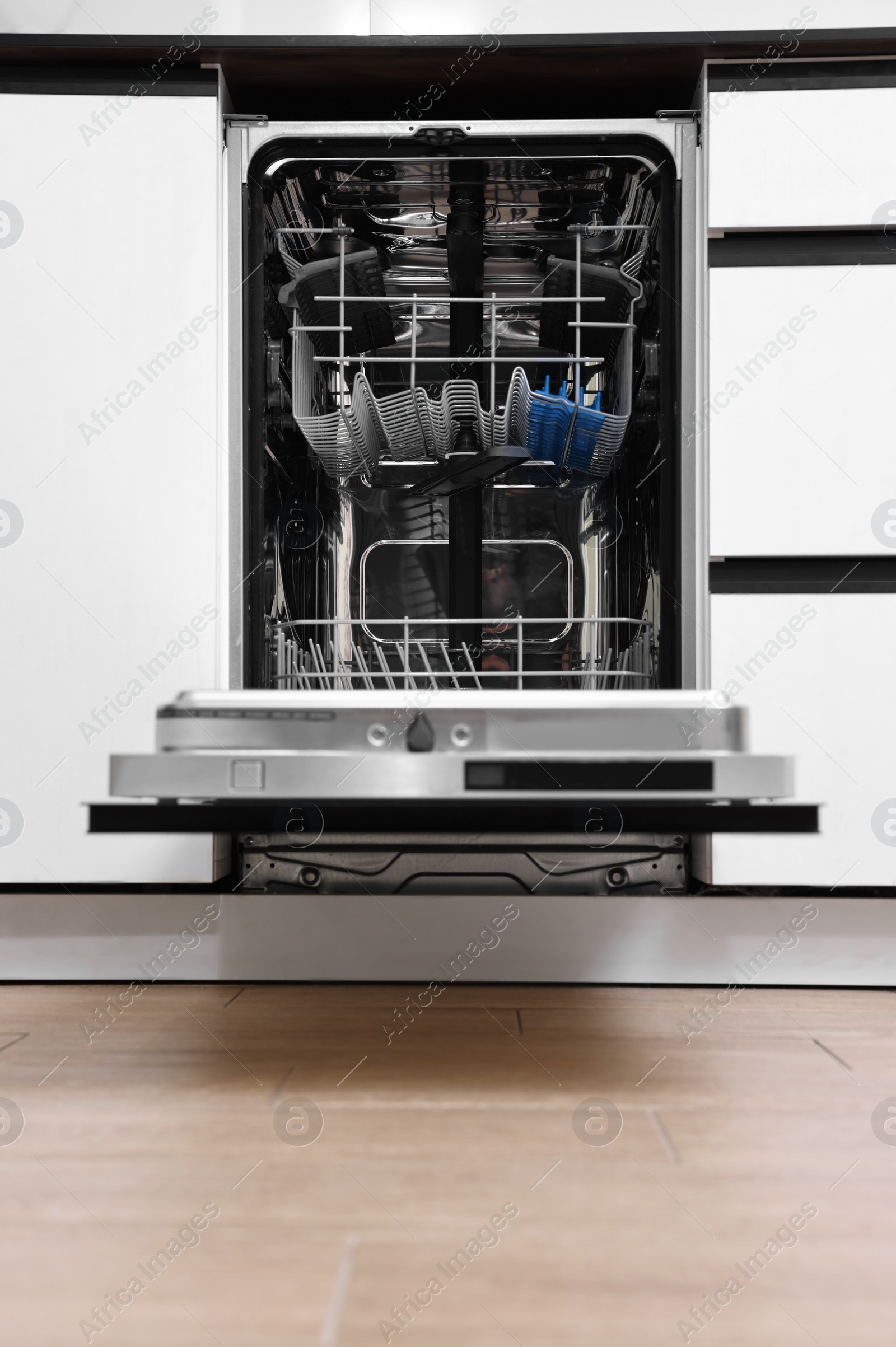 Photo of Built-in dishwasher with open door indoors. Home appliance