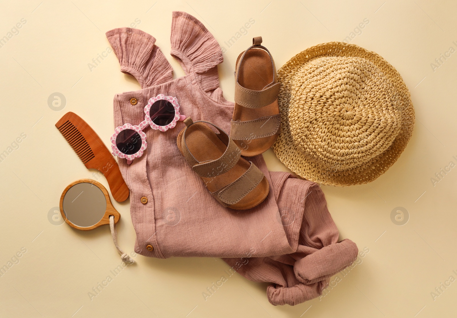 Photo of Stylish child clothes, shoes and accessories on beige background, flat lay