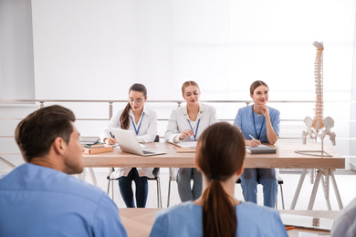 Photo of Medical students studying human spine structure in classroom