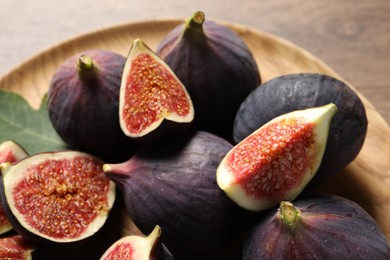 Whole and cut ripe figs on table, closeup