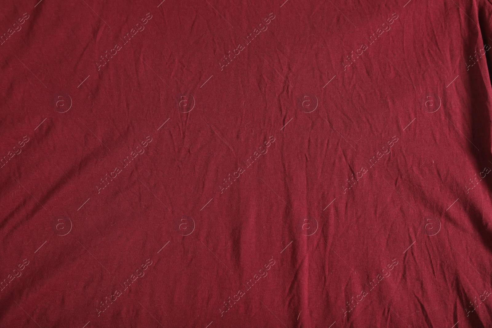 Photo of Crumpled dark red fabric as background, top view