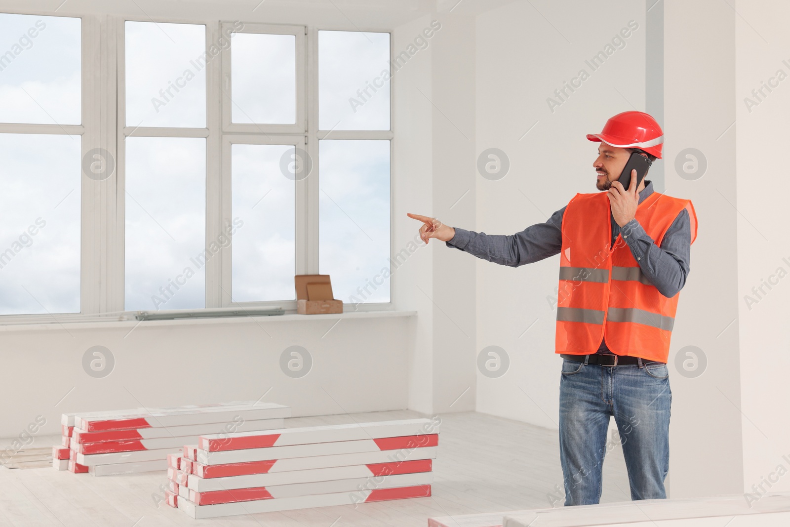 Photo of Male industrial engineer in uniform talking on phone indoors