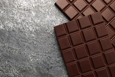 Delicious dark chocolate bars on grey table, flat lay. Space for text
