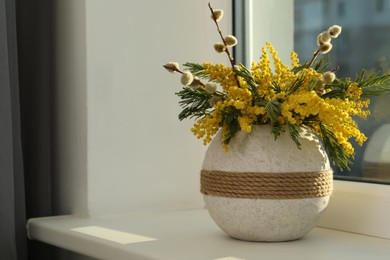 Photo of Beautiful mimosa flowers in vase on window sill indoors, space for text