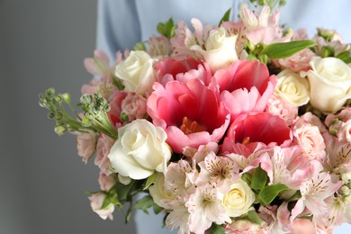 Photo of Woman with beautiful bouquet of fresh flowers on light background, closeup