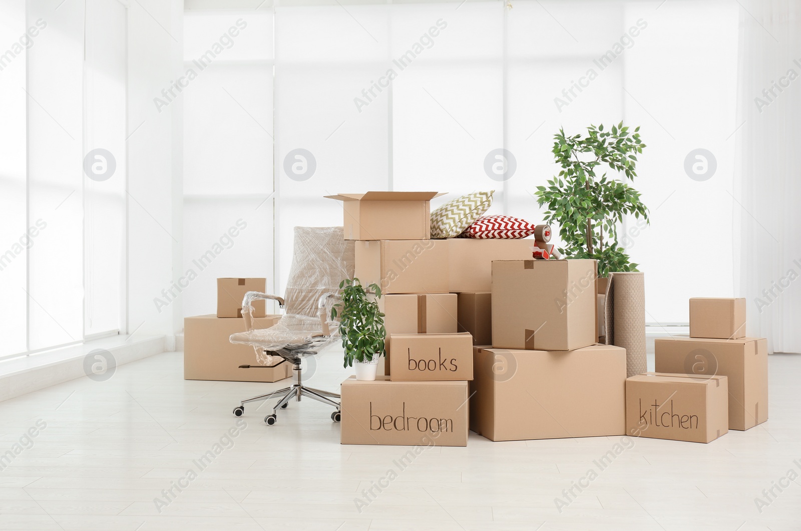 Photo of Pile of moving boxes in empty room