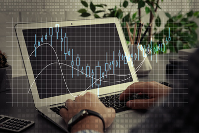 Image of Forex trading. Man working with laptop at table and chart, closeup