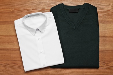 Photo of School uniform on wooden background, top view