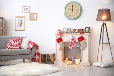 Photo of Room interior with decorative fireplace and Christmas lights indoors