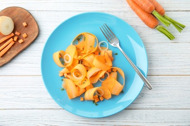 Plate with tasty carrot salad on table, top view