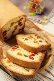 Photo of Delicious cake with candied fruits on white wooden table, closeup