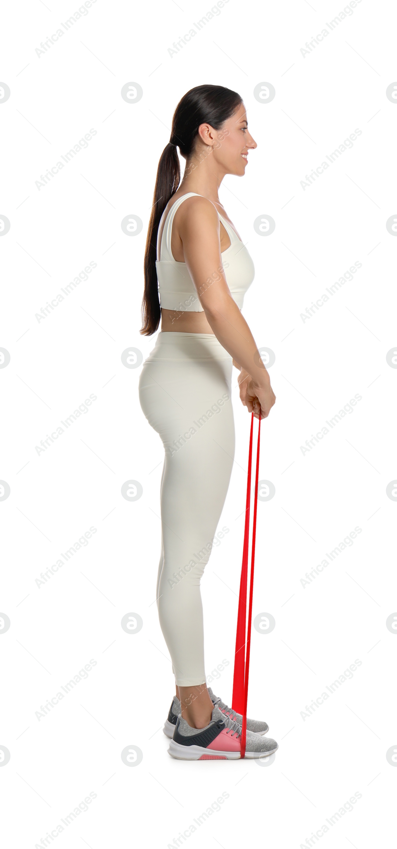 Photo of Woman doing sportive exercise with fitness elastic band on white background