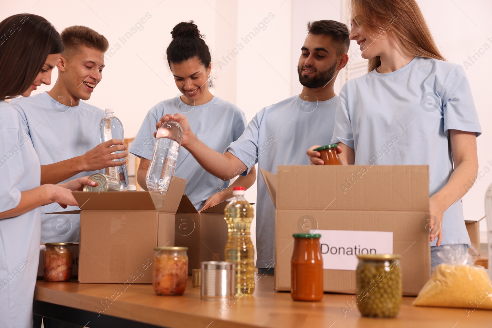 Photo of Group of volunteers packing food products in warehouse