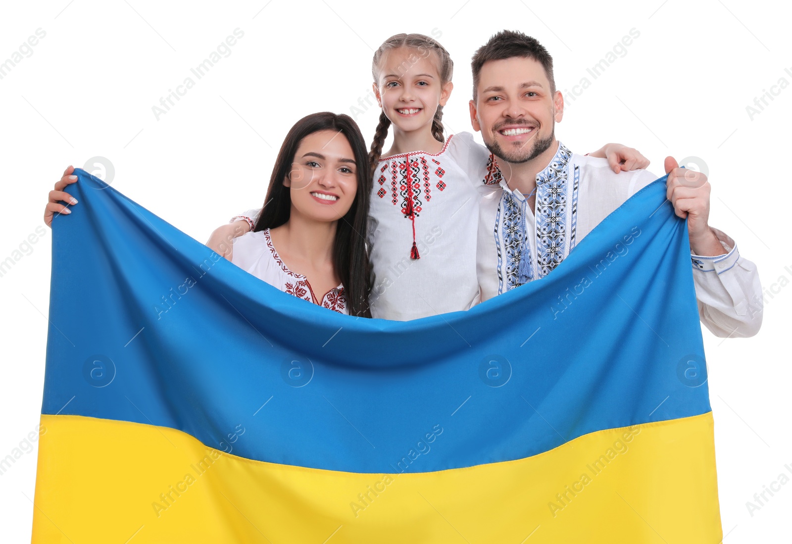 Photo of Happy family in national clothes with flag of Ukraine on white background