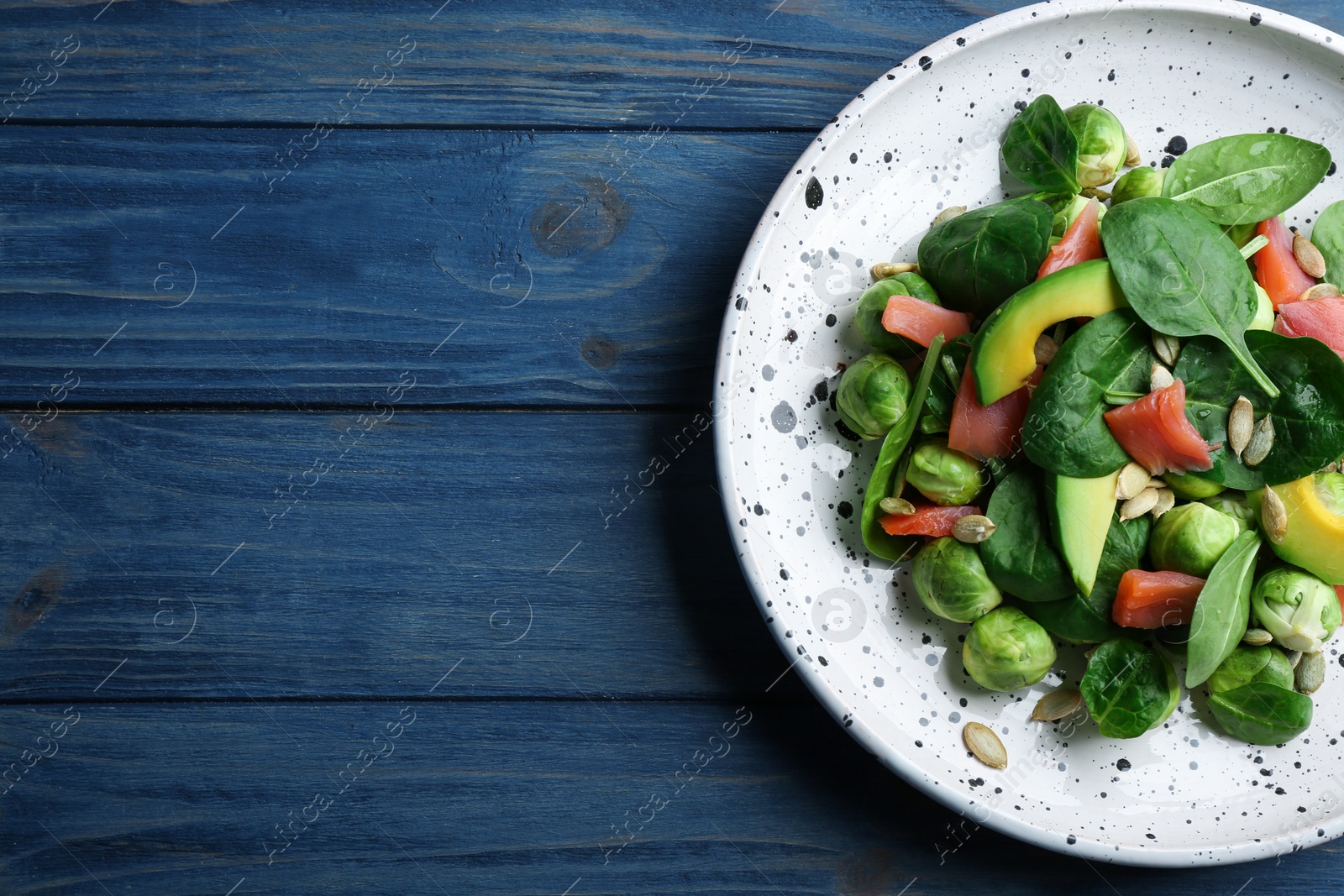 Photo of Tasty salad with Brussels sprouts on wooden table, top view. Space for text