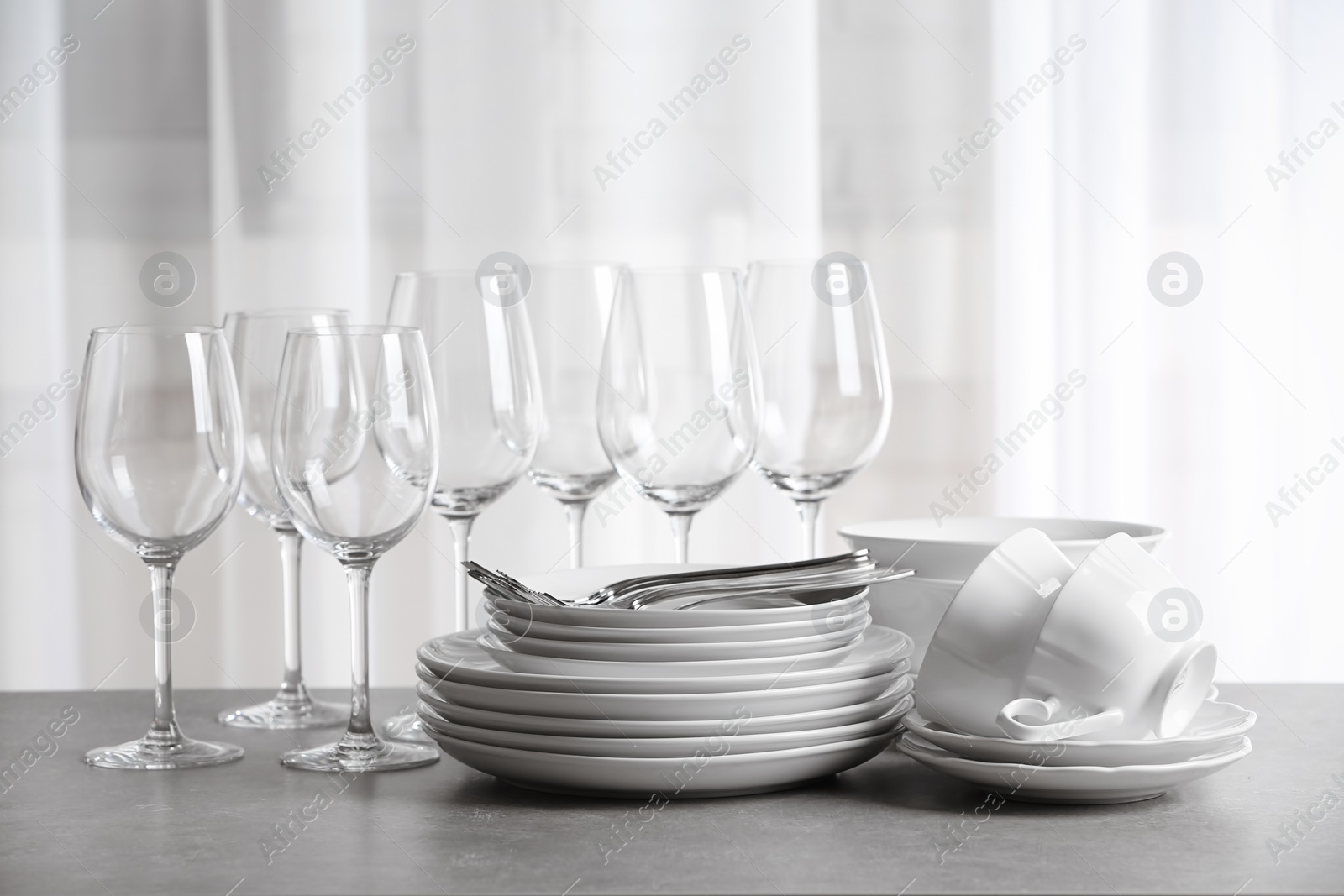 Photo of Set of clean dishes on the table against blurred background