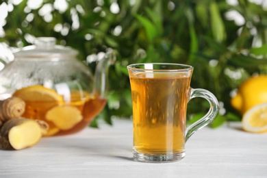 Photo of Glass cup of hot tea on white table