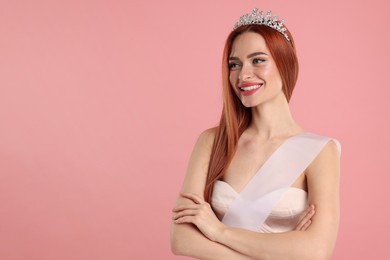 Photo of Beautiful young woman with tiara and ribbon on pink background, space for text
