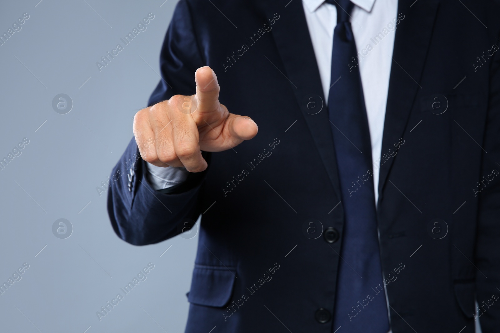 Photo of Businessman pointing on grey background, closeup of hand