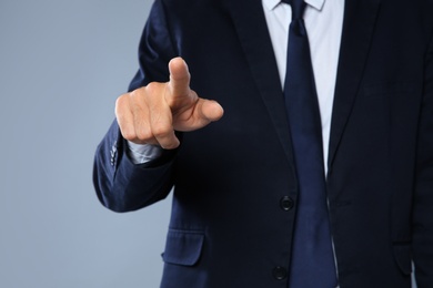 Photo of Businessman pointing on grey background, closeup of hand