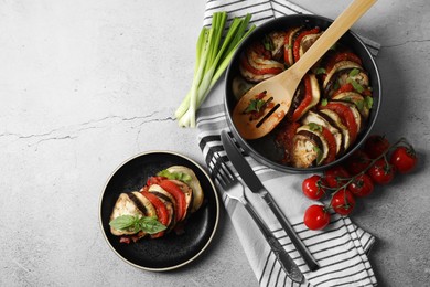 Photo of Delicious ratatouille served with basil on light grey table, flat lay. Space for text