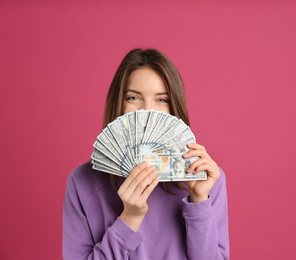 Young woman with cash money on pink background. Space for text