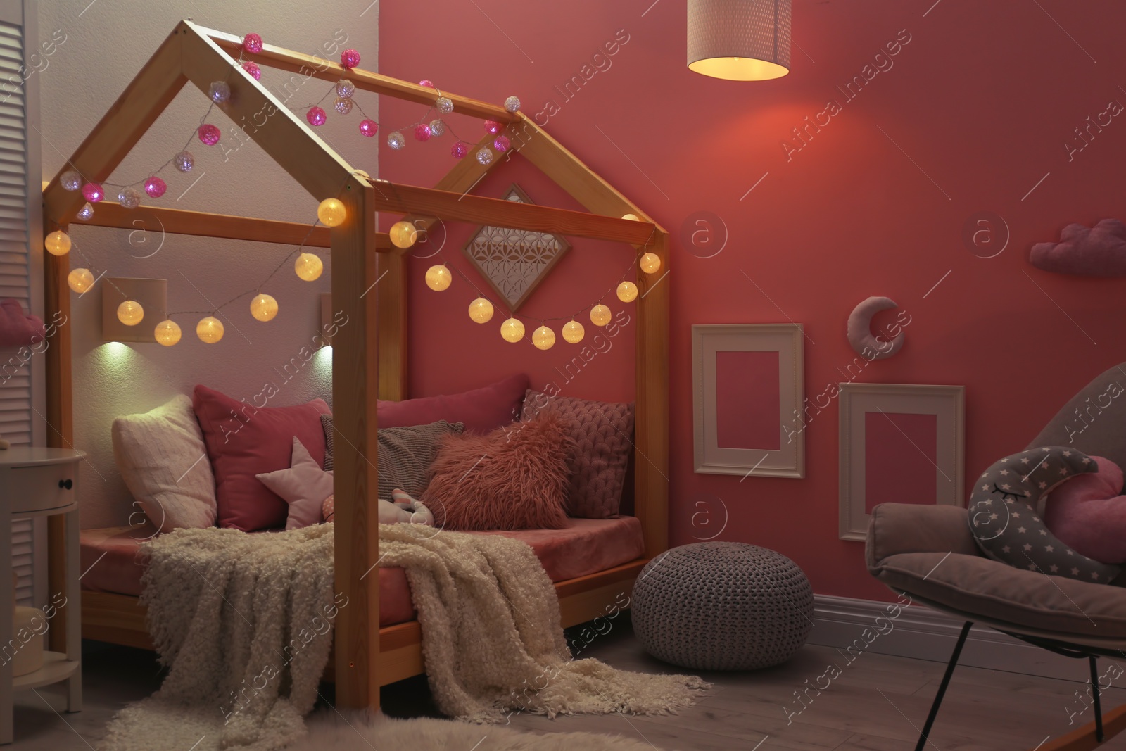 Photo of Child's room interior with comfortable bed and garland