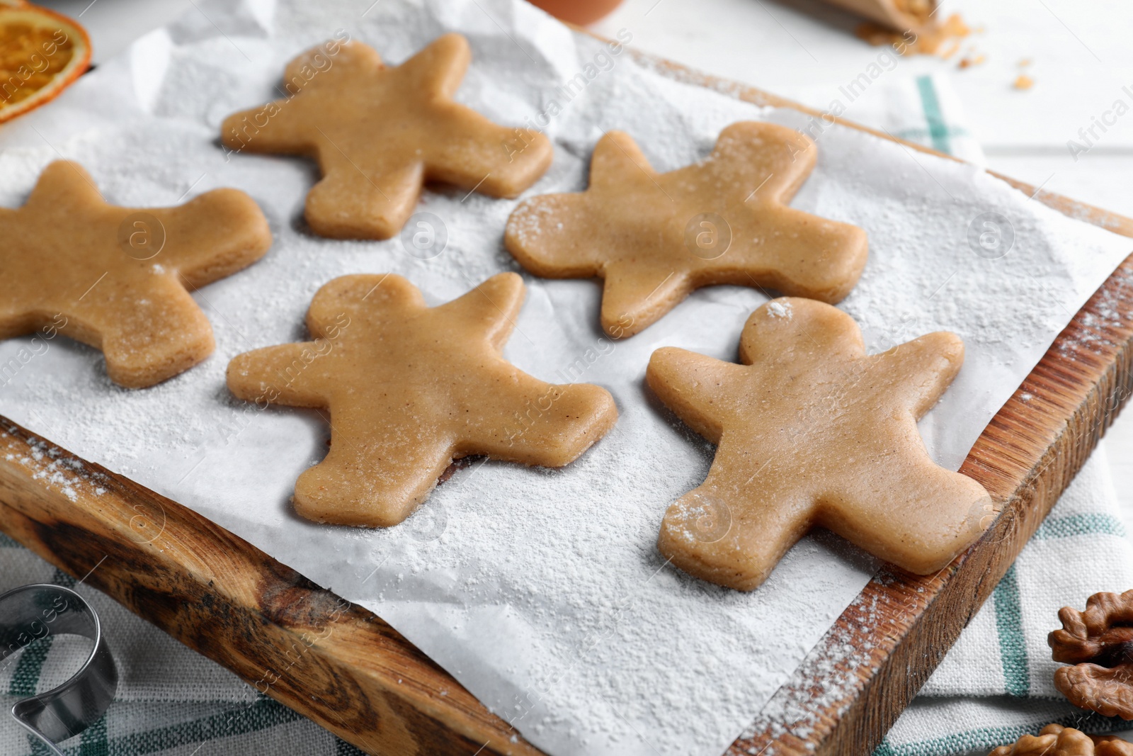 Photo of Making homemade Christmas cookies. Dough for gingerbread man on wooden board, closeup