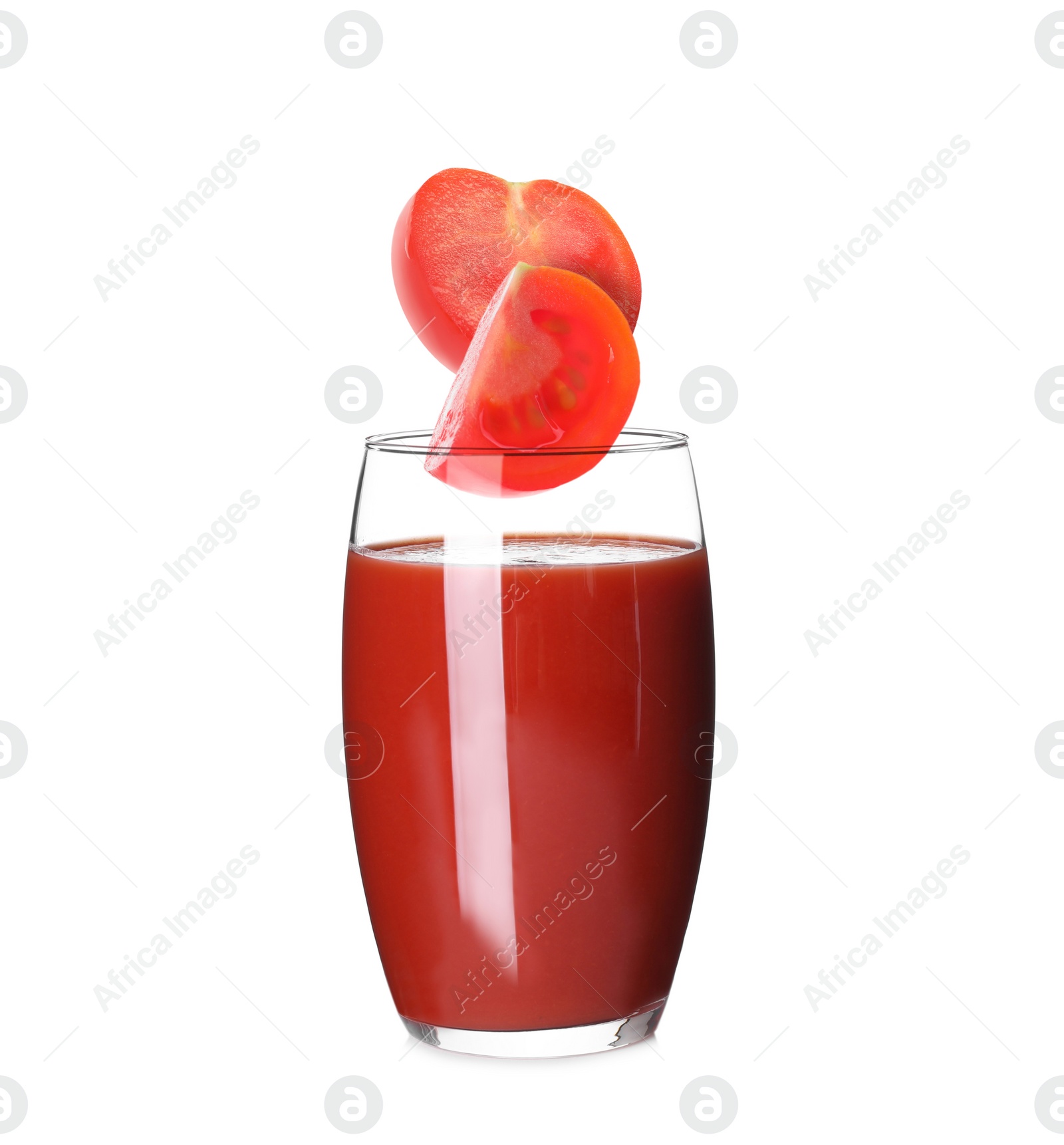 Image of Freshly made tomato juice on white background. Cut tomato falling into glass