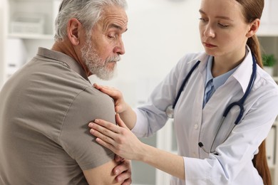 Photo of Arthritis symptoms. Doctor examining patient with shoulder pain in hospital